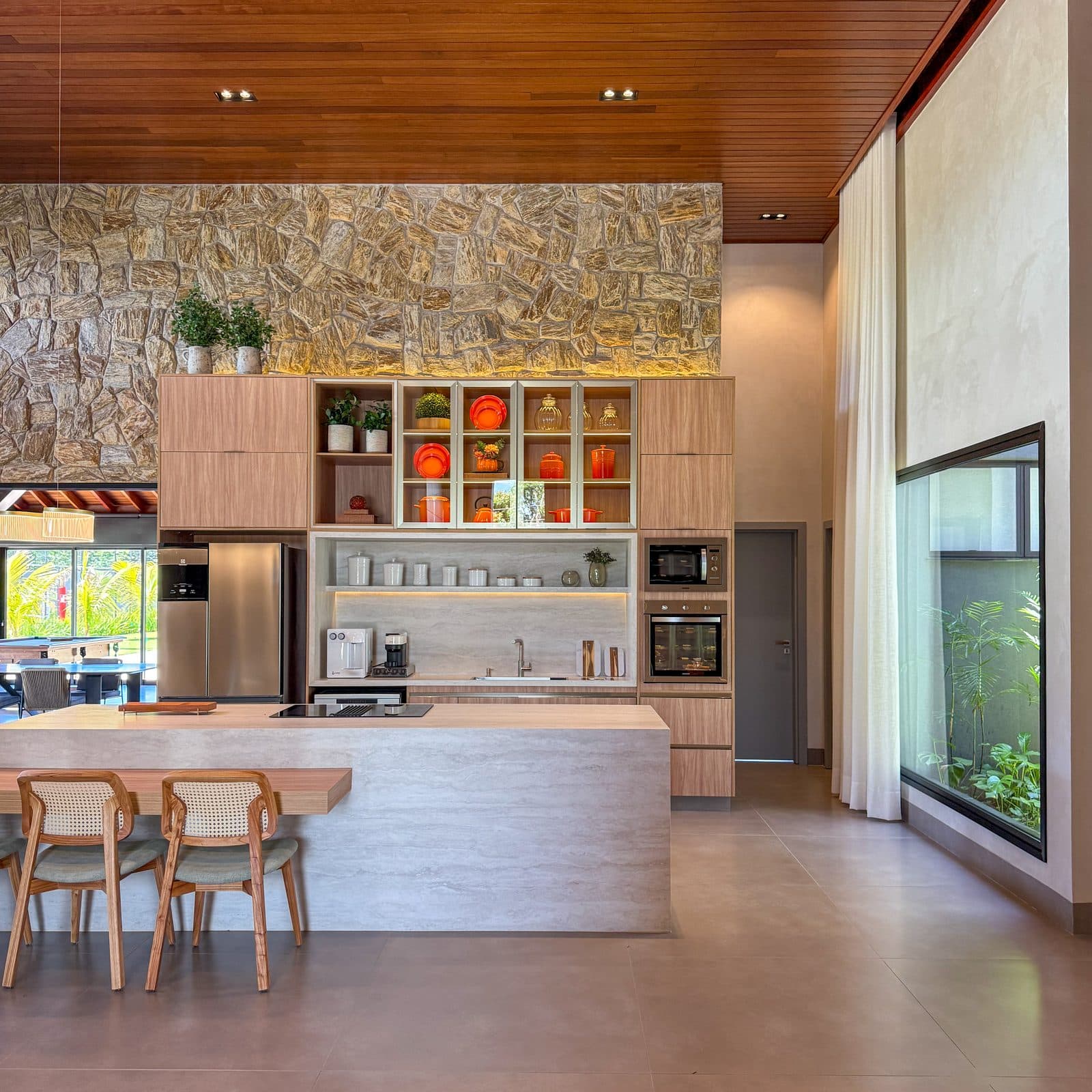Ambiente finalizado, cozinha integrada com parede de pedra